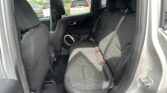 Interior of a car with black fabric backseat and headrests, viewed from the open rear door