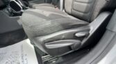 Interior of a car showing black fabric front seats, center console, and a paper floor mat on the driver’s side