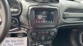 Interior of a car dashboard with center touchscreen displaying 'Climate Off', steering wheel on left, ignition/start button, and a paper flyer on the floor reading 'We Take Pride In Your Vehicle!'