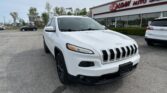 White Jeep SUV parked in the foreground outside EZ Loan Auto Sales showroom.
