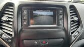 Car infotainment touchscreen showing a backup/around-surroundings view with the message 'Check entire surroundings' on top.