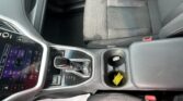 Close-up of a car interior showing the center console, gear shifter, cup holder, and passenger seat upholstery.