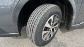 Close-up of a car's front wheel and tire in the wheel well, showing an alloy rim and dark fender area.