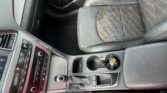 Center console with gear shifter, cup holder, and climate controls in a car interior