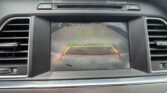 Rearview camera display on car dash with colored parking guide lines (green, yellow, red).