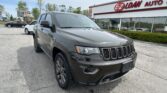 Dark gray Jeep SUV parked in a dealership lot with the E-Z LOAN AUTO storefront in the background.