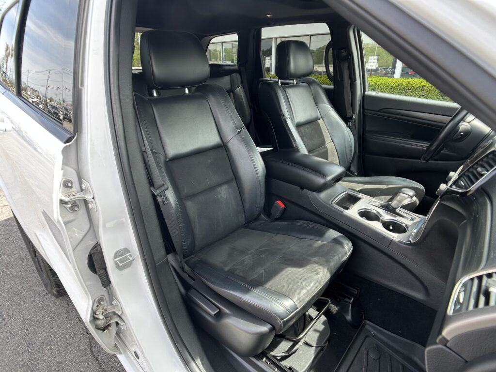 Inside view of a car's front seats: black leather driver and passenger seats with center console between them