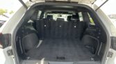 Open SUV trunk with rear seats upright and spacious cargo area visible in a parking lot.