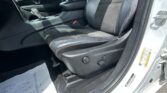Driver's seat and center console of a car, with black upholstery and visible seatbelt, door frame on the right.