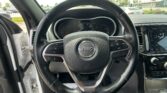 Close-up of a Jeep steering wheel with the instrument cluster and center console visible in the background.