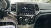 Center touchscreen climate control panel on a car dashboard with air vents and control knobs nearby