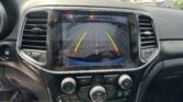 Infotainment screen showing rearview camera with green/yellow/red guide lines and 'Check Entire Surroundings' message