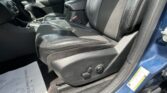 Front interior of a car with black leather seats, center console, and gear shifter visible by the door.