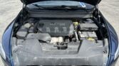 Car engine bay with hood open, showing a 2.4L Multiair engine cover and battery on the right side