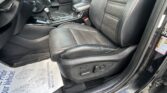 Interior of a car showing front seats in black leather, center console with gear shifter, and door panel in view.
