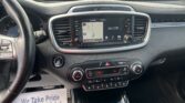 Infotainment screen showing a map with AV Off on a car’s center console; steering wheel visible to the left and climate controls below.