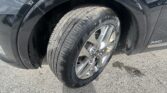 Close-up of a black SUV wheel and tire with a chrome rim; visible AWD badge on the fender.