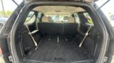SUV cargo area with third-row seats folded down; beige headrests visible in the back row behind the empty trunk space