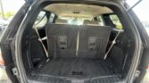 Open SUV cargo area with third-row seats upright and rear cabin visible