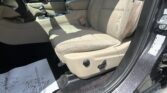 Interior of a car with tan/beige seats, center console and gear shifter visible, passenger seat and door frame on the right.