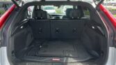Rear hatch open on SUV showing cargo area with folded rear seats and rubber floor mats inside the trunk