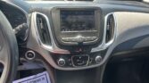 Center console with touch-screen radio displaying 96.9 Rock, climate dials below, and visible parking lot through the windshield.