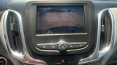 Center infotainment screen shows the rearview camera with orange parking lines over a parking lot scene for parking guidance.