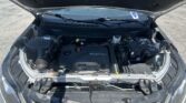Car with hood open, engine bay visible including ECOTEC engine cover and battery in daylight