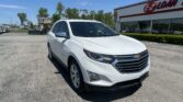 White Chevrolet SUV parked diagonally in a lot in front of an E-Z Loan storefront on a sunny day.
