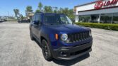 Blue Jeep SUV parked in a parking lot in front of an E-Z LOAN storefront on a sunny day.