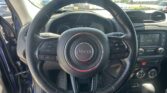 Close-up of a Jeep steering wheel from the driver's seat, with the dashboard and center console in view behind it to the right and left