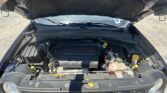 Open hood showing engine bay of a car with a 3.4L multiAir engine cover visible and battery components at the front.