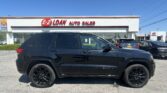 Front view of a black SUV parked in a car dealership lot with an E-Z LOAN Auto Sales sign on the building behind it.