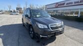 Front three-quarter view of a gray SUV parked in a dealership lot with EZ Loan Auto Sales building in the background.