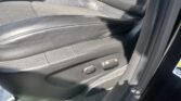 Front interior: black leather car seat with side adjustment controls and part of the center console visible
