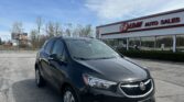 Black Buick SUV parked in front of EZ Loan Auto Sales building on a clear day with blue sky.
