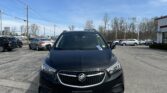 Front view of a black Buick SUV parked in a car lot on a sunny day with a blue sky above.