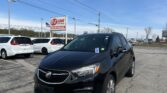 Black Buick SUV in a car dealership lot with EZ Loan Auto Sales sign and other white vehicles nearby under a clear blue sky.