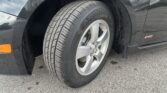 Close-up of a car front wheel and tire, black bodywork with an RS badge on the fender.