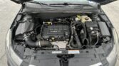 Open car hood showing engine bay with EcoTec engine cover and various hoses and reservoirs visible under the hood