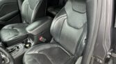 Black leather front seats inside a Jeep SUV, with visible seat belts and center console between them.
