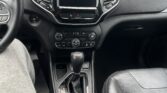 Front interior of a car with a blank center touchscreen, two air vents, and a gear shifter visible between the seats.