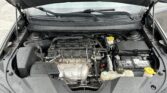 Front view of an open car hood exposing the engine bay, battery, and coolant reservoir.