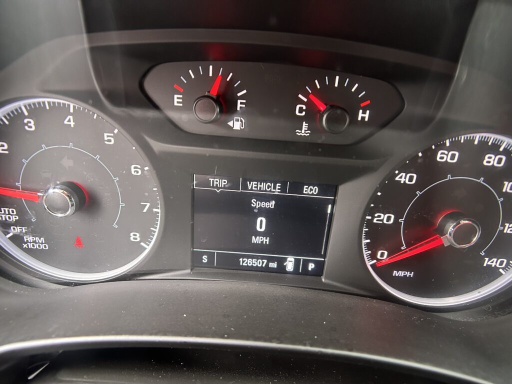 Center of a car dashboard showing the tachometer, speedometer, and a digital display reading 0 mph with 126,507 miles on the odometer.