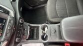 Interior of a car showing the center console with cup holders, gear selector, climate controls, and passenger seat seen from above.