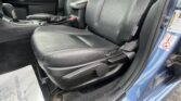 Close-up of the car's front interior showing the driver seat, center console, and a rusted metal threshold near the door by the floor mat.