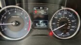 Instrument cluster with red car-door warning on center display; speedometer to the right and tachometer to the left. The message reads 'Door Liftgate/Trunk Open'.