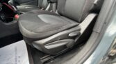 Front interior of a dark car showing the front passenger seat, center console, gear shifter, and a paper mat on the floor with printed text.