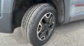 Close-up of a gray SUV wheel and tire in the wheel well, with mud on the fender and inner lining visible.