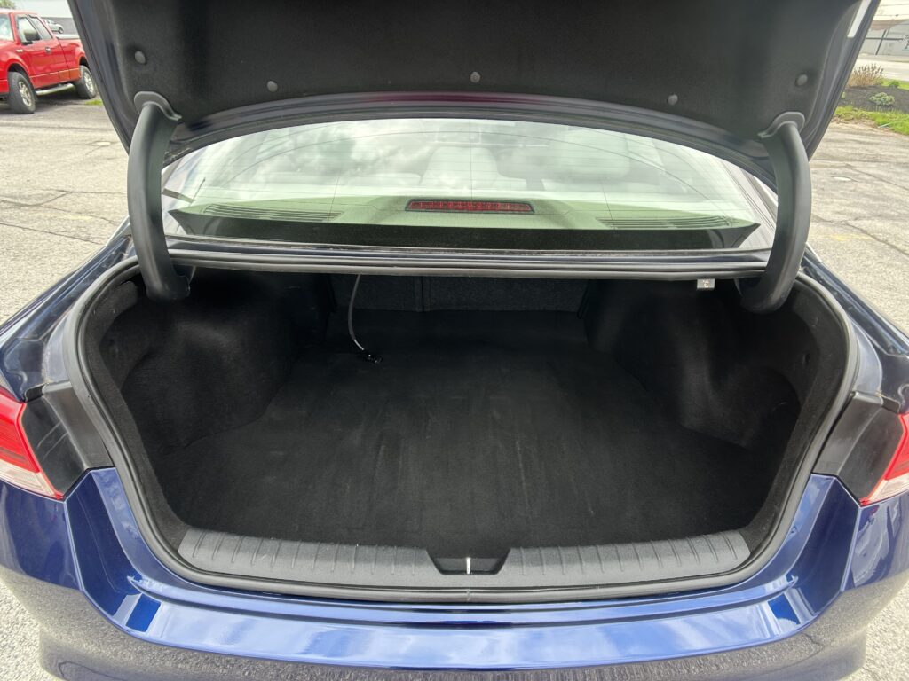 Blue sedan with its trunk open, revealing a spacious cargo area and rear seats.